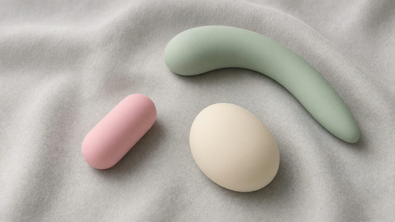 Verschillende soorten vibrators in zachte kleuren op een lichte ondergrond